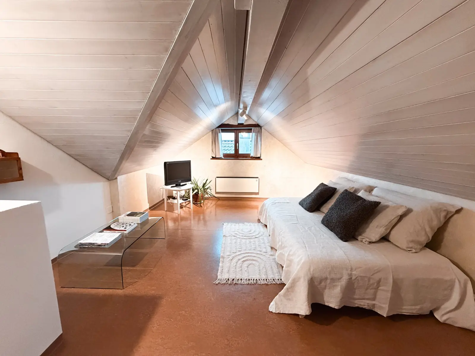 Loft sitting and sleeping room beneath the pitched roof in Brione