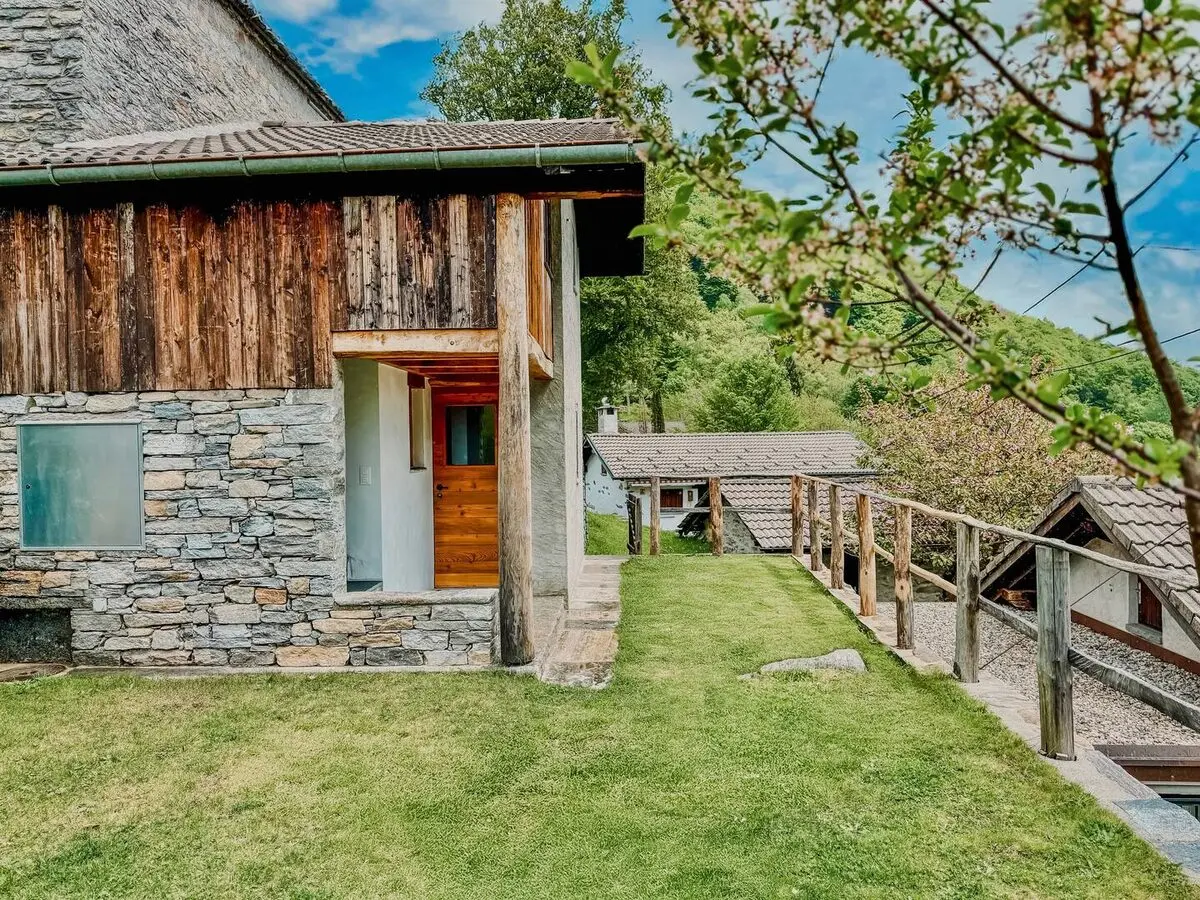 Restored timber-and-stone cabin and garden at Monti Motti
