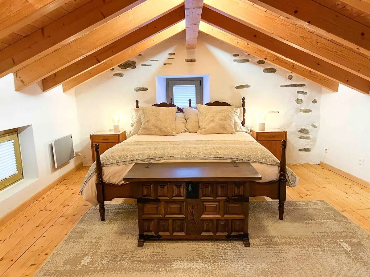 Loft bedroom beneath timber beams in Vergeletto